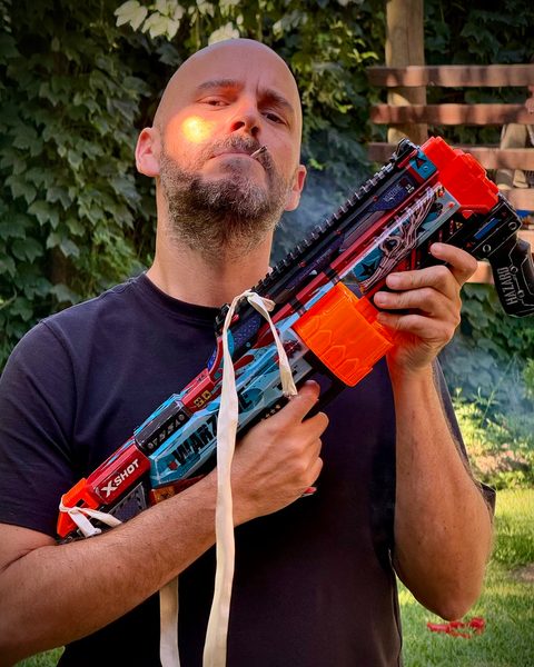 Juan striking an action-hero pose with a toy blaster