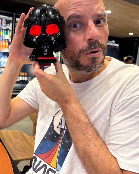 Juan holding a toy Darth Vader head with glowing red eyes next to his face